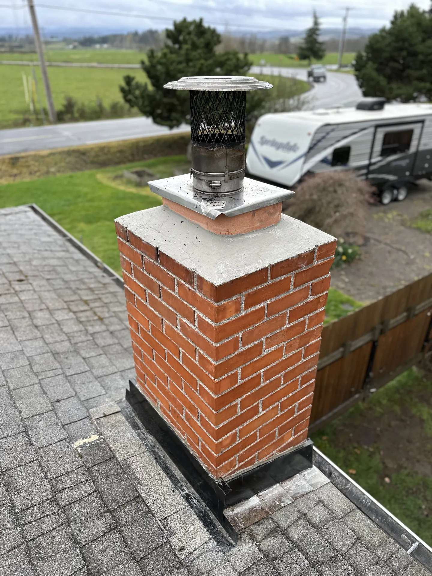 Chimney rebuild before and after in Estacada: a mossy, cracked crown with failing flashing, rebuilt with fresh brick, a new crown, and step flashing